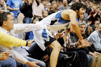 Ricky Rubio, sujetado por un espectador, en su debú en la NBA ante Oklahoma.