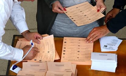 Tres ciudadanos con derecho a voto cogen las papeletas para el Senado en un colegio de Girona.