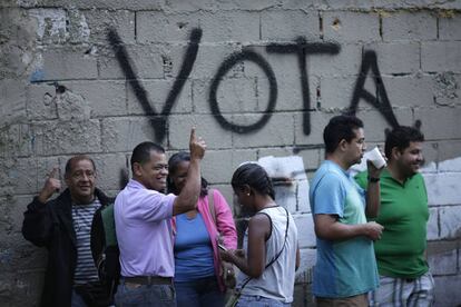 Un grupo de personas espera su turno para votar en el exterior de un colegio electoral en Caracas.