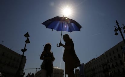 Turistes es protegeixen de la calor a la Puerta del Sol de Madrid.