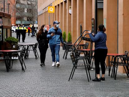Una camarera prepara la terraza del restaurante donde trabaja para atender a sus clientes en el turno de 13:00h a 16:30h, en L'Hospitalet de Llobregat.