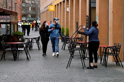 Una camarera prepara la terraza del restaurante donde trabaja para atender a sus clientes en el turno de 13:00h a 16:30h, en L'Hospitalet de Llobregat.