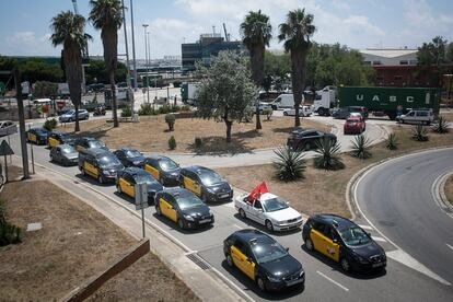 Marcha lenta de taxistas a su paso por el acceso de la zona franca al Puerto de mercaderias, en Barcelona.