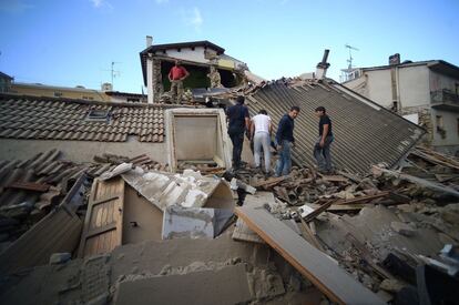 Moradores de Amatrice buscam sobreviventes entre os restos de várias casas.