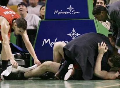 Calderón acude a ayudar a Garbajosa, tendido en el suelo tras torcerse el tobillo en el partido contra los Celtics de Boston.