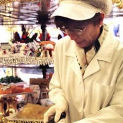 Una dependienta de una pastelería parte turrón