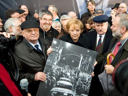 (FILES) In this file photo taken on November 9, 2009 Former Russian President Mikhail Gorbachev (L), German Chancellor Angela Merkel (C) and former Polish President Lech Walesa hold a signed print of people crossing the Boesbrucke border bridge as they crossed the sam bridge during a ceremony to mark the 20th anniversary of the fall of the wall in Berlin. - The last leader of the Soviet Union, Mikhail Gorbachev, died on August 30, 2022 at the age of 91 in Russia, said a hospital quoted by Russian news agencies. (Photo by LEON NEAL / AFP)