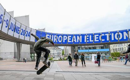 Un patinador salta cerca de los anuncios de las próximas elecciones de la Unión Europea frente al edificio del Parlamento Europeo en Bruselas.