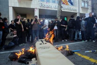 Un muñeco arde frente a la Bolsa de Barcelona, simulando la muerte de la universidad pública.