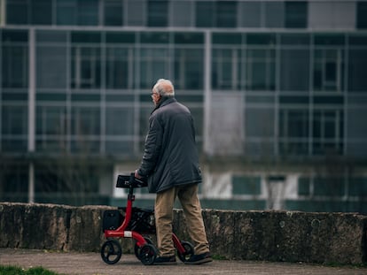 Un hombre dependiente de avanzada edad, con movilidad reducida, realiza un paseo como parte  de su trabajo de mantenimiento, este lunes.