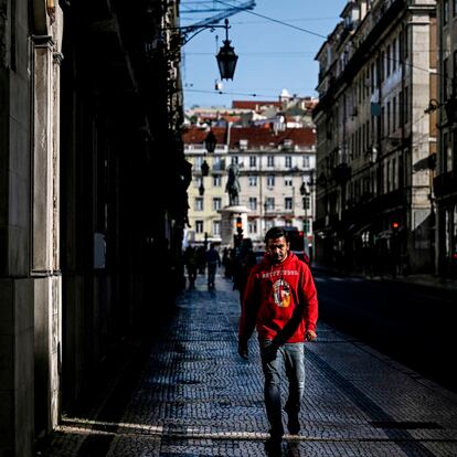 Un hombre camina por una calle de Lisboa.