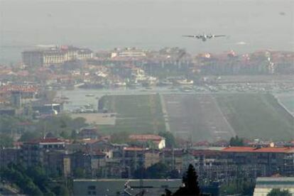 Un avión se dispone a tomar tierra en el aeropuerto de Hondarribia, con Hendaya al fondo.