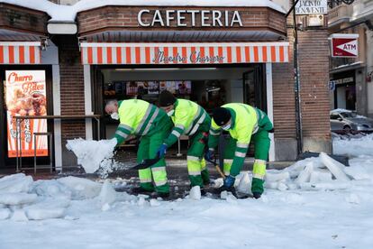 Operarios del Ayuntamiento de Madrid se afanan en limpiar la nieve de la plaza de Jacinto Benavente, este lunes.