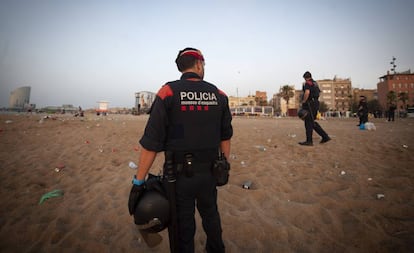 'Mossos' en la playa de la Barceloneta tras la verbena de San Juan.