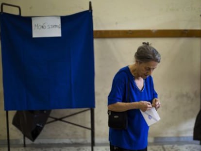 Una mujer sostiene su papeleta antes de votar, en Atenas.