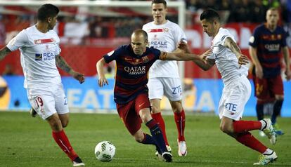 Iniesta conduce el bal&oacute;n rodeado de rivales.