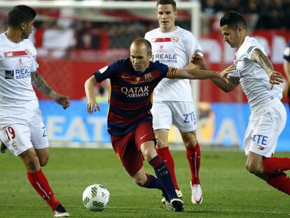 Iniesta conduce el bal&oacute;n rodeado de rivales.