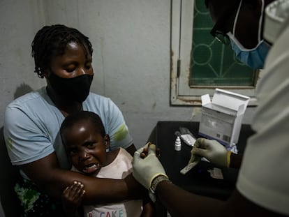 Un sanitario hace una prueba rápida de diagnóstico de malaria a una niña en el hospital de Mopeia, en Mozambique.