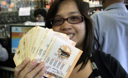 Una mujer muestra todos los billetes adquiridos para la lotería Mega Millions