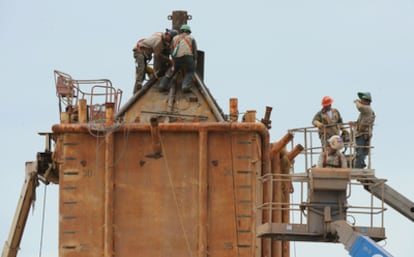 Trabajadores de BP trabaja en el montaje de una cúpula que pretenden instalar encima del pozo para facilitar la extracción del crudo.