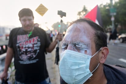 Manifestantes vierten leche en los ojos de personas afectadas tras recibir gases lacrimógenos cerca del Centro de Detención Metropolitano en el centro de Los Ángeles.