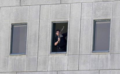 Un miembro de las fuerzas de seguridad se asoma a una ventana del Parlamento iraní en Teherán.