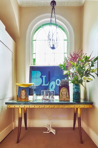 Detalle de uno de los descansillos de la escalera. Sobre la mesa, a la derecha, retrato de Allegra, y a la izquierda, de una de sus hijas, ambos realizados por la artista Julia Condon. La lámpara es una de las piezas de la nueva colección de latón de Hicks.