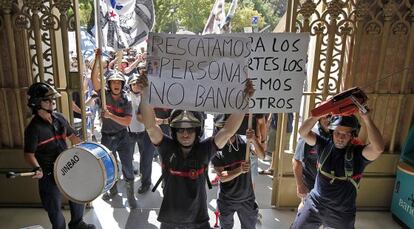 Los manifestantes entran en una sucursal bancaria para protestar por los recortes.