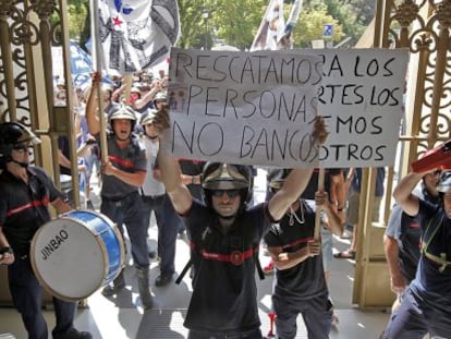 Los manifestantes entran en una sucursal bancaria para protestar por los recortes.