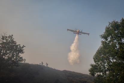 Un avión asiste a la 'Brigada Hormiga' en las tareas de extinción del incendio en Pentes, Ourense.