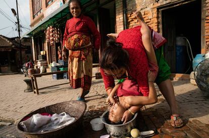 Una madre lava el cabello de su hija en Katmandú (Nepal), el 23 de abril de 2016.