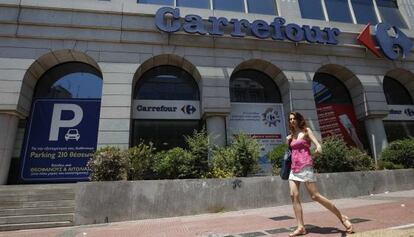 Una mujer ante un supermercado de Carrefour en Atenas.