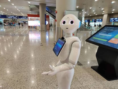 Robot en el aeropuerto para recordar a los pasajeros que se protejan con mascarilla.