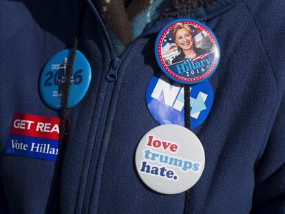 Un seguidor de la candidata presidencial estadounidense por el Partido Demócrata, Hillary Clinton, luce botones que apoyan su candidatura durante un acto de su campaña electoral, el 24 de octubre de 2016, en el St Anselm College de Manchester, New Hampshire (EE UU).