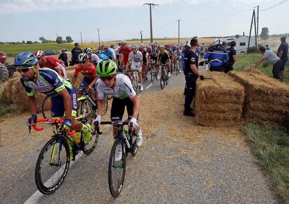 El pelotón reanuda la marcha entre pacas de paja tras haber sido detenida momentáneamente la décimosexta etapa del Tour.