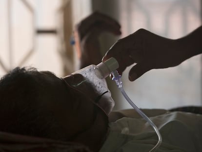 A relative adjusts the oxygen mask of a tuberculosis patient at a TB hospital on World Tuberculosis Day in Hyderabad, India, on March 24, 2018.