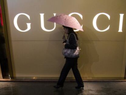 Una mujer camina frente a una tienda de Gucci en Guangzhou (China). Reuters