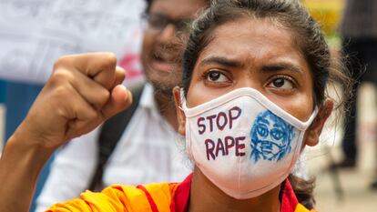 Una estudiante en cuya mascarilla se lee 'Stop violación' alza el puño durante una manifestación contra la violencia machista en el país en Dhaka, capital de Bangladés, el pasado 8 de octubre de 2020. Las protestas comenzaron tres días antes, después de la difusión en redes sociales de un vídeo de una mujer siendo atacada sexualmente y torturada por un grupo de hombres.