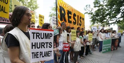 Participantes en la concentración convocada por Greenpeace frente a la Embajada de Estados Unidos para protestar por la decisión del presidente de Estados Unidos, Donald Trump, de sacar a su país del Acuerdo de París.