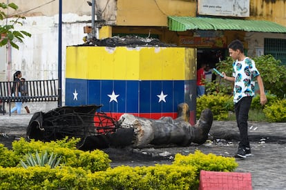 Una estatua destruida de Hugo Chávez yace junto a su base en Valencia, Venezuela.
