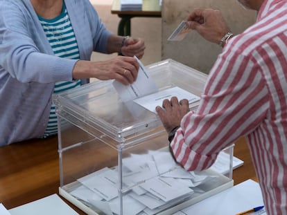 Una persona introduce la papeleta en una urna de un colegio electoral de Sevilla, este domingo.