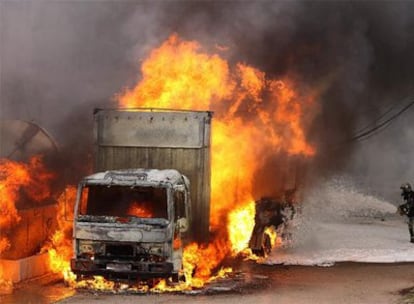 Un bombero trata de apagar el incendio de un camión que se hallaba dentro de la fábrica de Ercros, en Aranjuez.