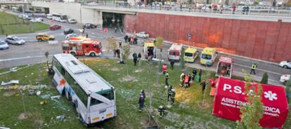 Los servicios de emergencias rodean el autobús accidentado de General Motors, ayer en Zaragoza.