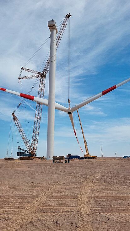 La grúa coloca las palas de la turbina eólica.