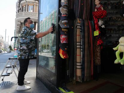 A worker cleans the window to a store in the center of Madrid.