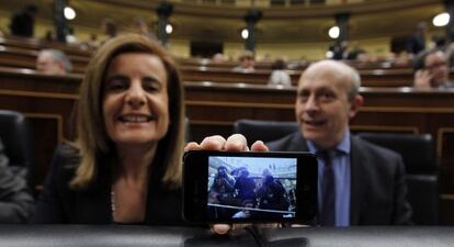 La ministra de Empleo, Fátima Báñez, muestra su móvil, donde recoge la imagen de los fotógrafos que en ese momento la enfocan. Al lado, el ministro de Educación, José Ignacio Wert.