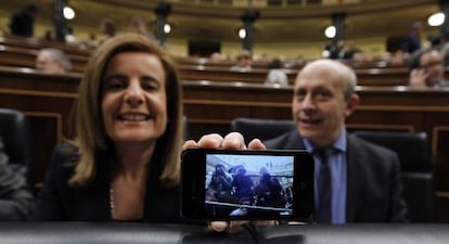 La ministra de Empleo, Fátima Báñez, muestra su móvil, donde recoge la imagen de los fotógrafos que en ese momento la enfocan. Al lado, el ministro de Educación, José Ignacio Wert.