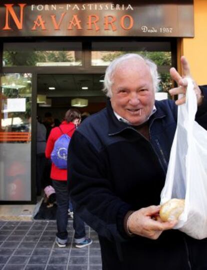 A pensioner displays a loaf purchased from Pepe Navarro´s bakery