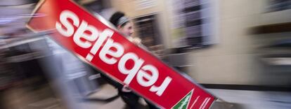 Una dependienta de una gran superficie de Córdoba prepara el cartel de rebajas.