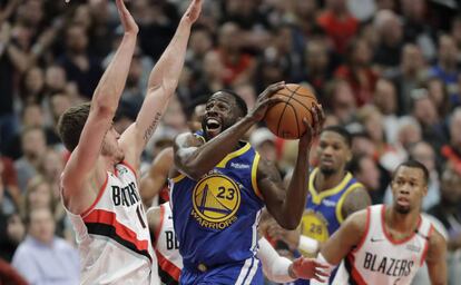 Draymond Green intenta superar a Leonard.